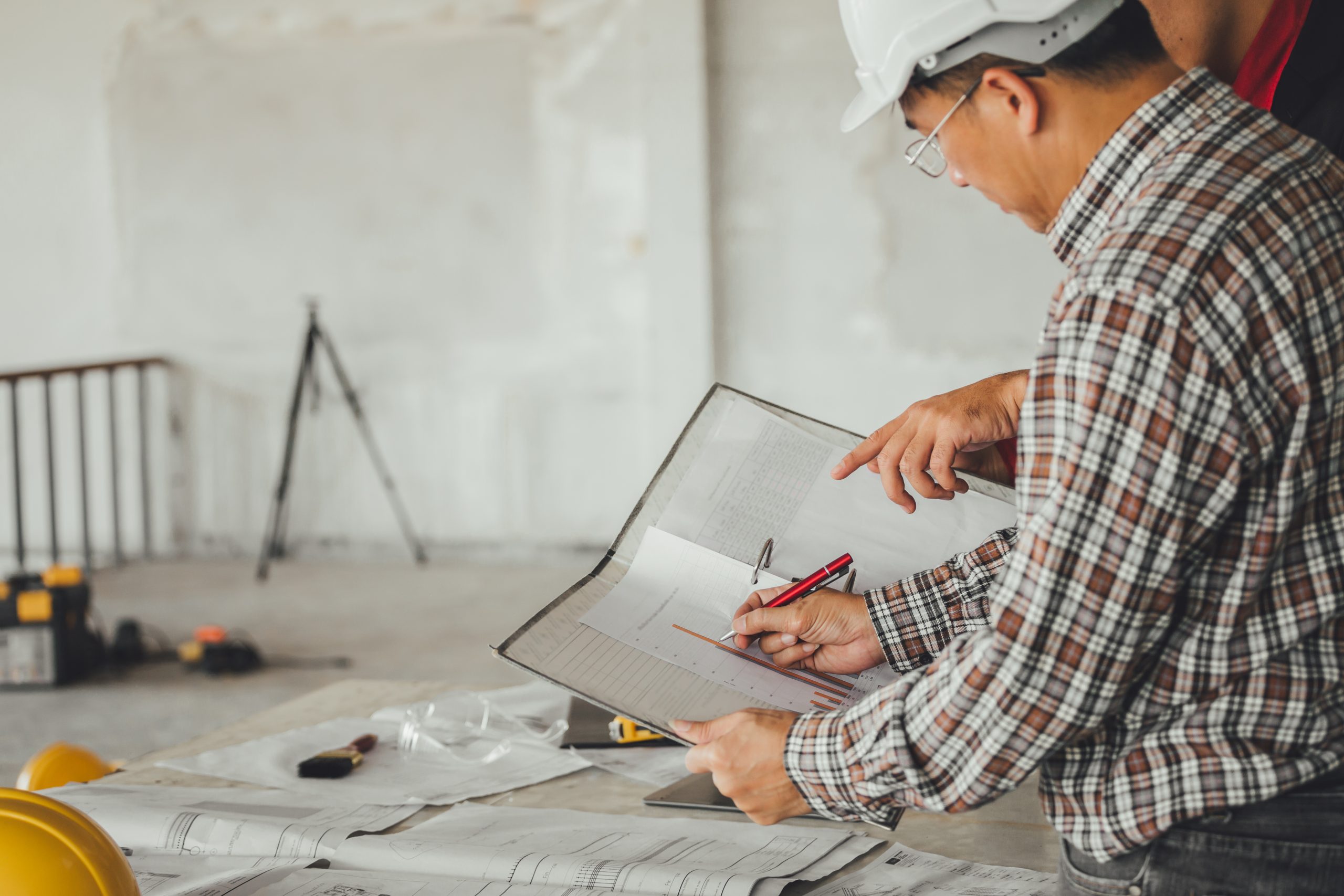 arquitecto con planos en mano delineando scaled